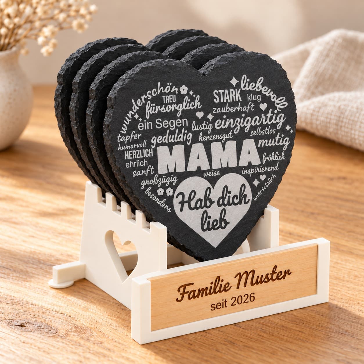 Vier Schieferherz-Untersetzer im cremefarbenen Halter mit personalisierbarer Holzplakette; vorne das MAMA-Motiv