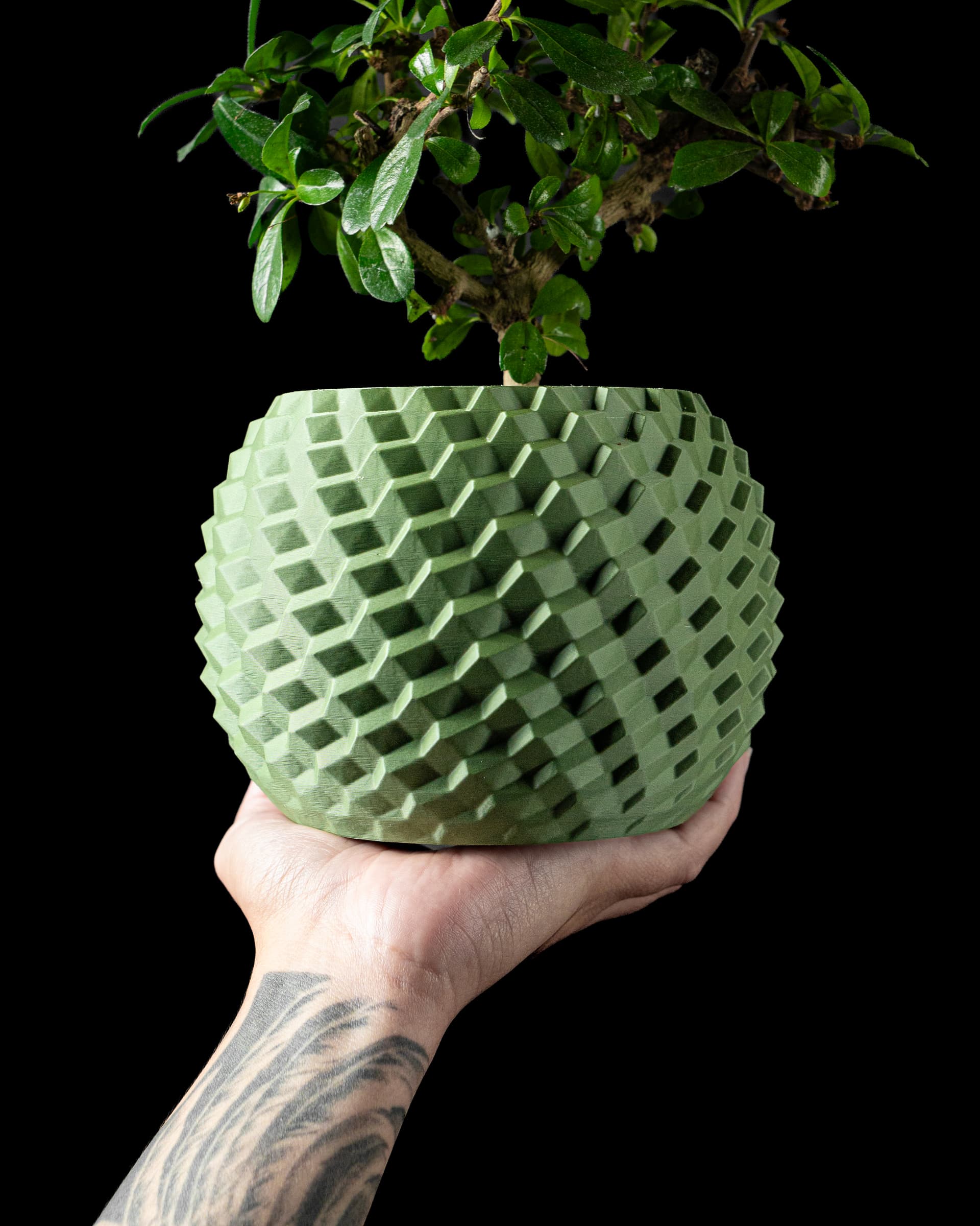3D-Blumentopf Cobble Planter — gepflastertes Kubus-Muster in Hellgrün, bauchige Form, Hand hält Topf