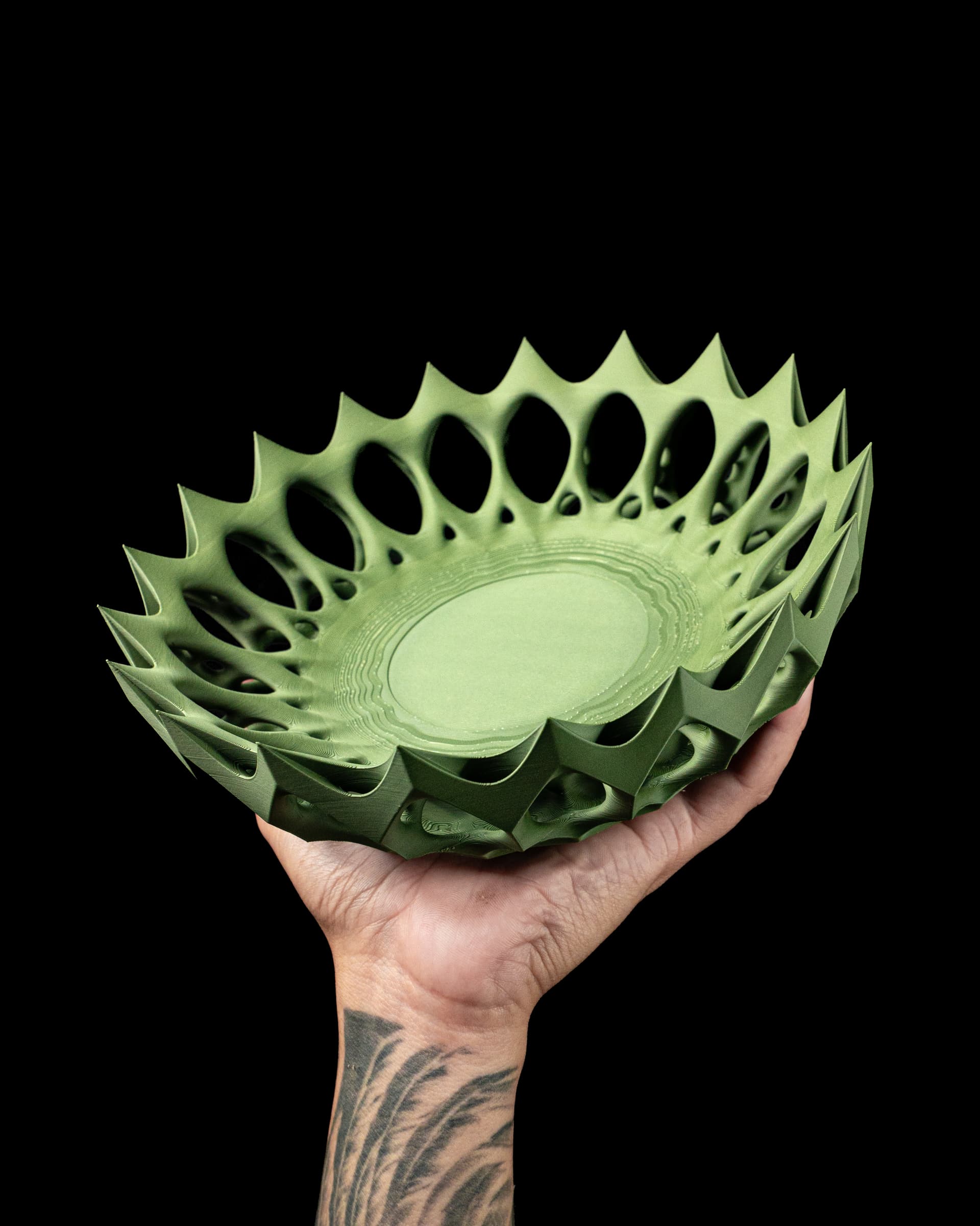 Invader Tray 3D-Druck in Grün — Schale mit stacheligen Zackenkrone und organischen Löchern, in Hand gehalten, schwarzer Studiohintergrund