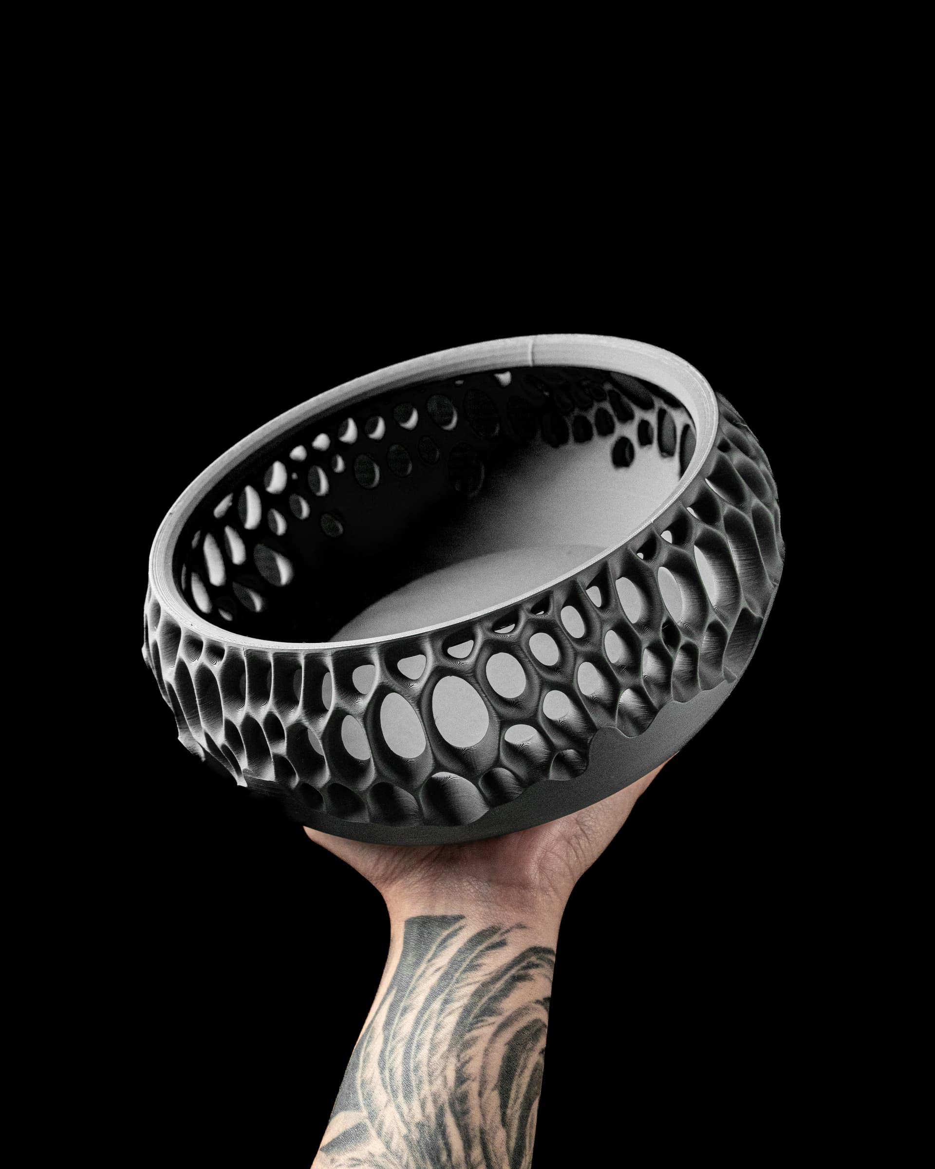 Virus Catch-all Bowl 3D-Druck schwarz — hohe zylindrische Schale mit biomorphen Voronoi-Löchern, schräg gehalten vor schwarzem Hintergrund