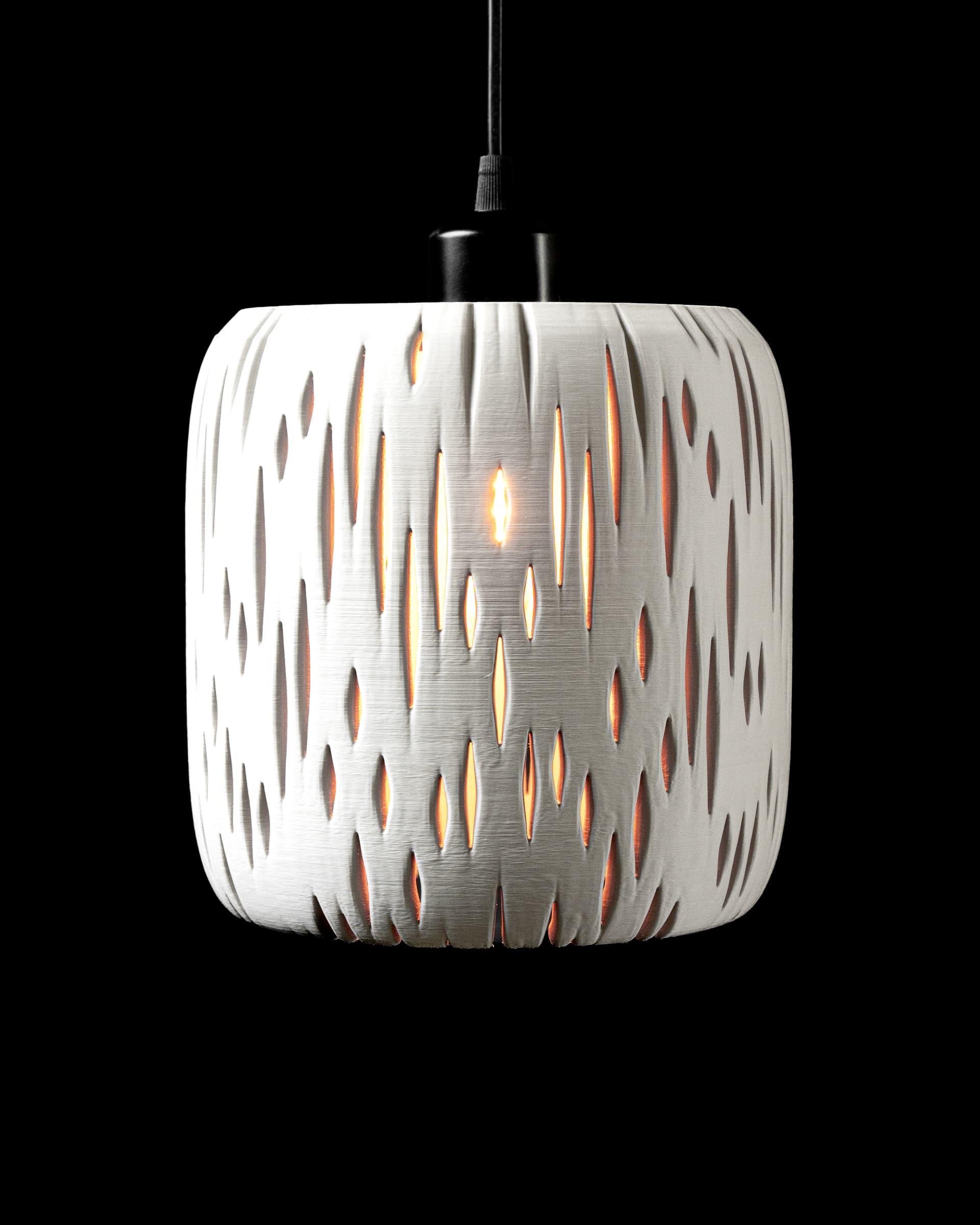 3D-Pendelleuchte Birch — weißer Zylinderschirm mit mandelförmigen Schlitzen, beleuchtet, Flammenbirne sichtbar