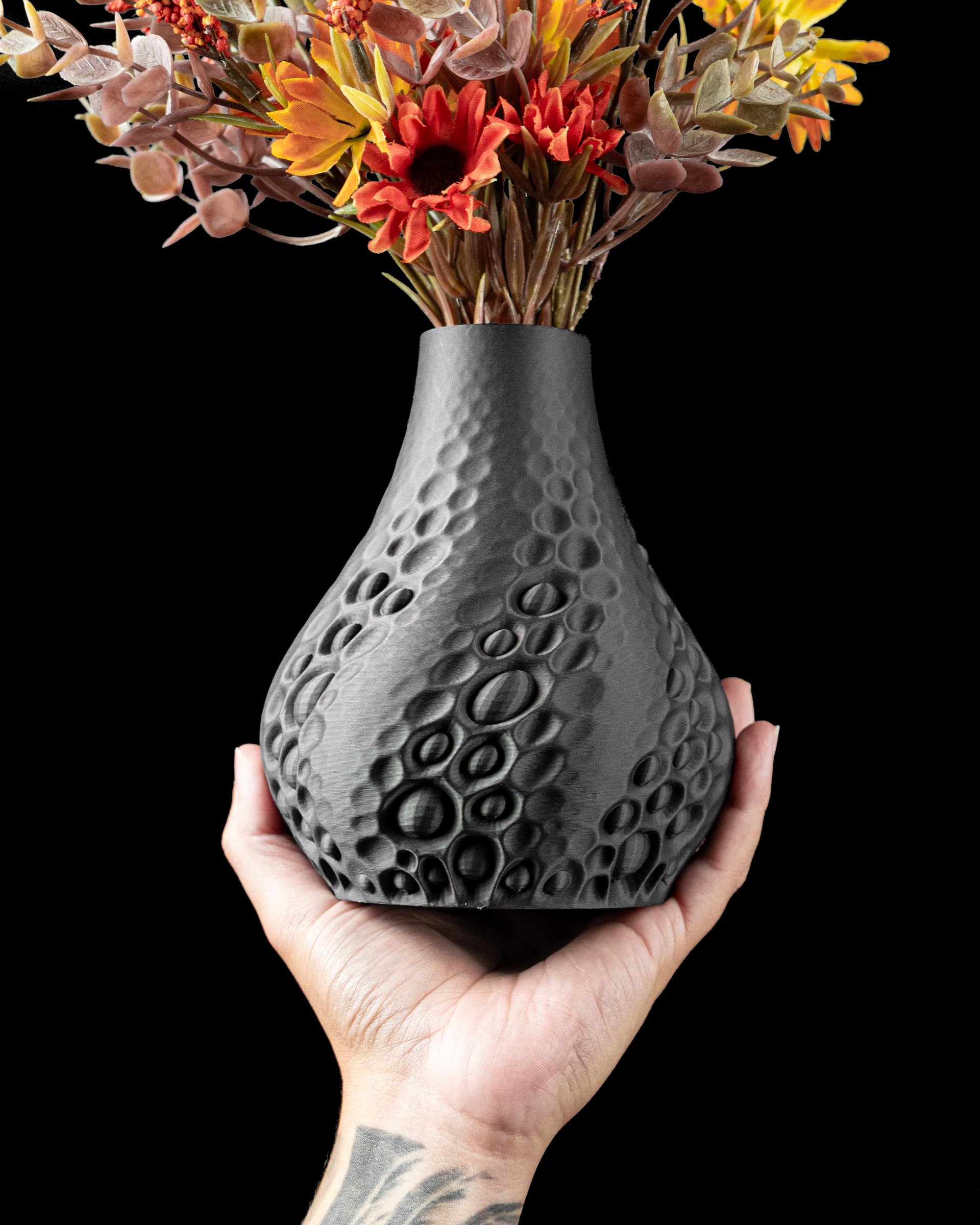 Pearl Flower Vase — dunkelgraue 3D-Druck-Vase mit Perlenrelief, in einer Hand gehalten, schwarzer Hintergrund