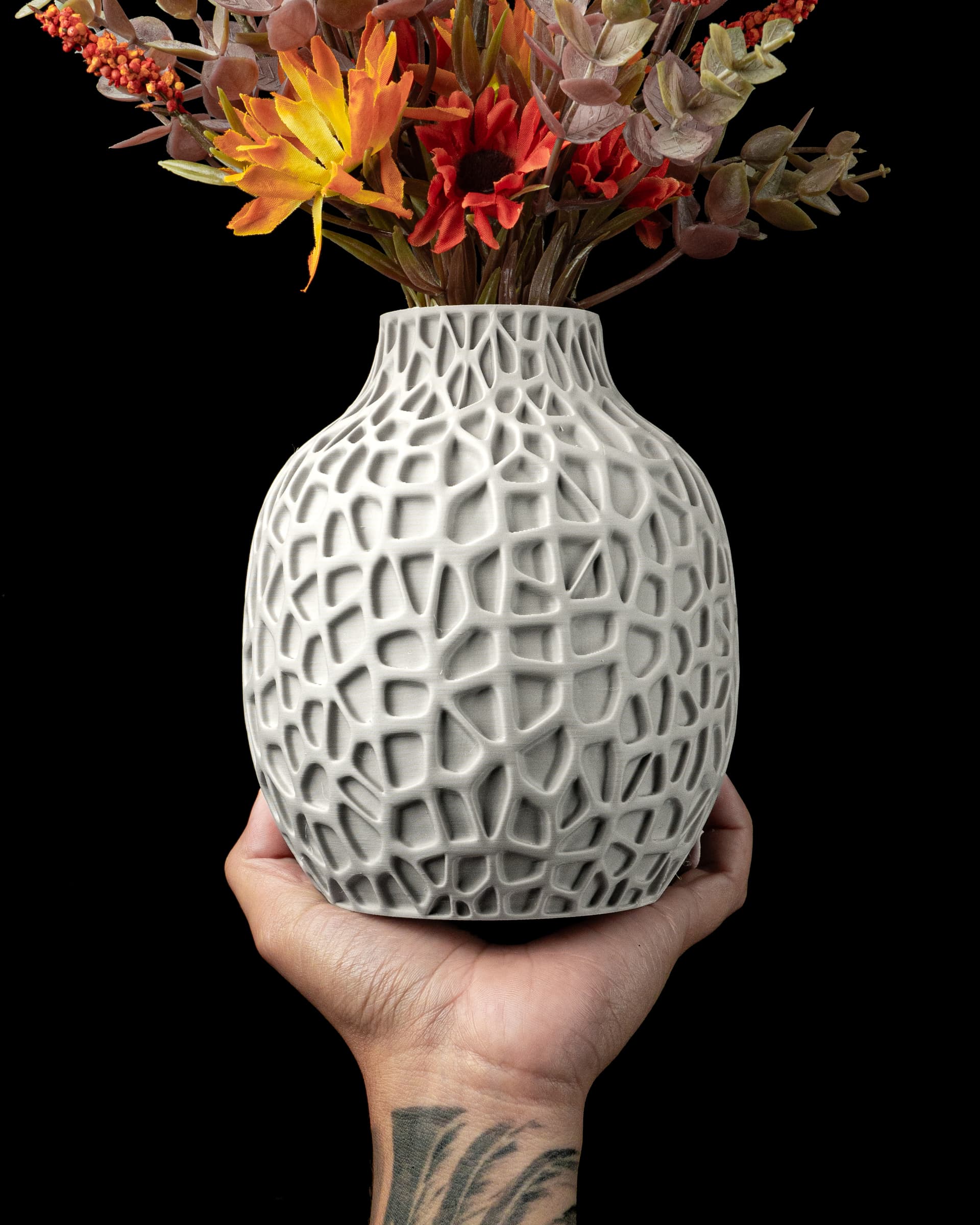 Pulp Flower Vase weiß in Hand — runder Vasenkörper mit organischem Voronoi-Netz, Herbstblumen, tattowiertes Handgelenk