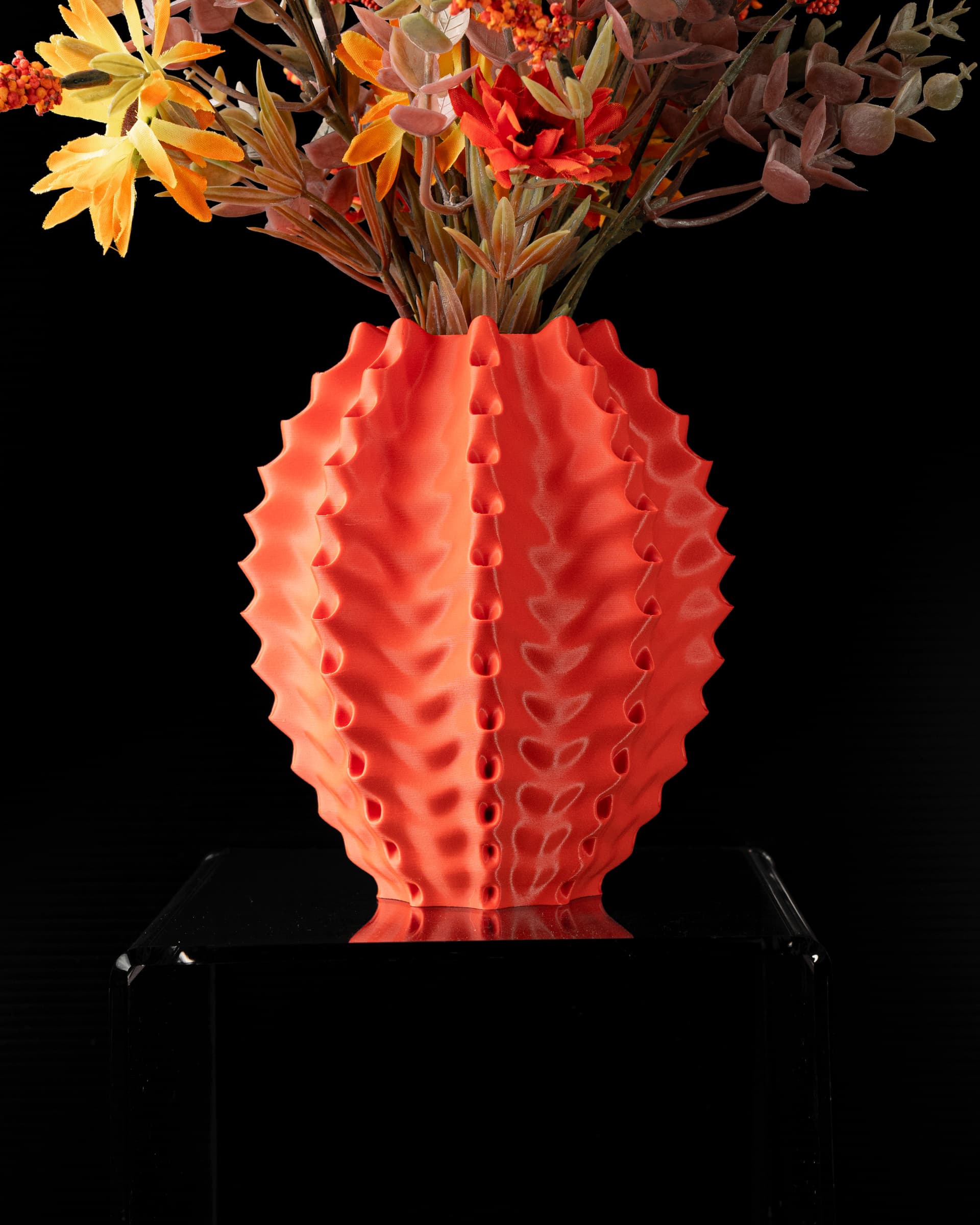 Vilo Flower Vase v2 korallrot mit Trockenblumen — breite ovale Form, vertikale Stachelrippen mit Noppen, Frontansicht