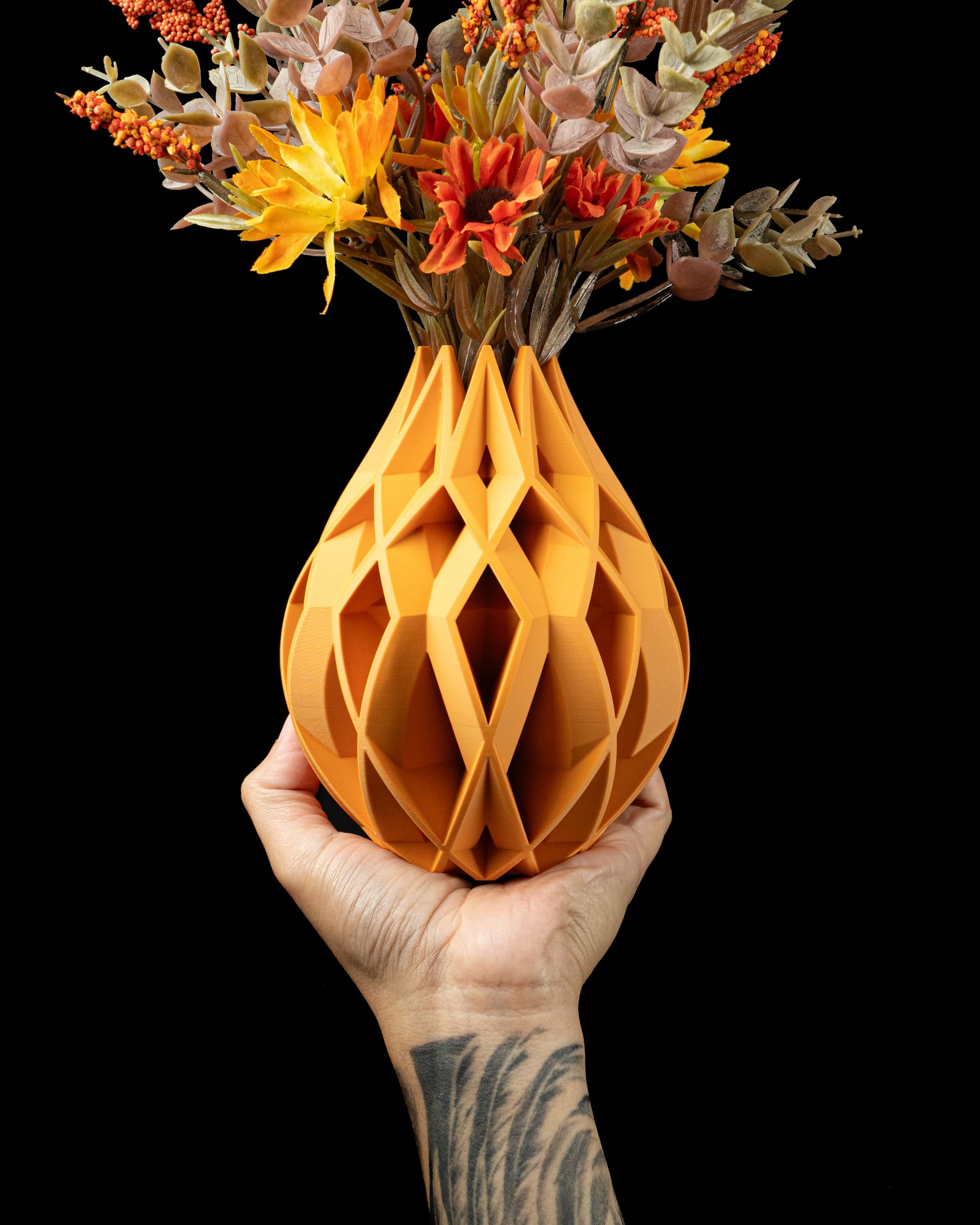 Von Flower Vase orange in Hand — tropfenförmige Vase mit geometrischen Rautenöffnungen, Trockenblumenstrauß
