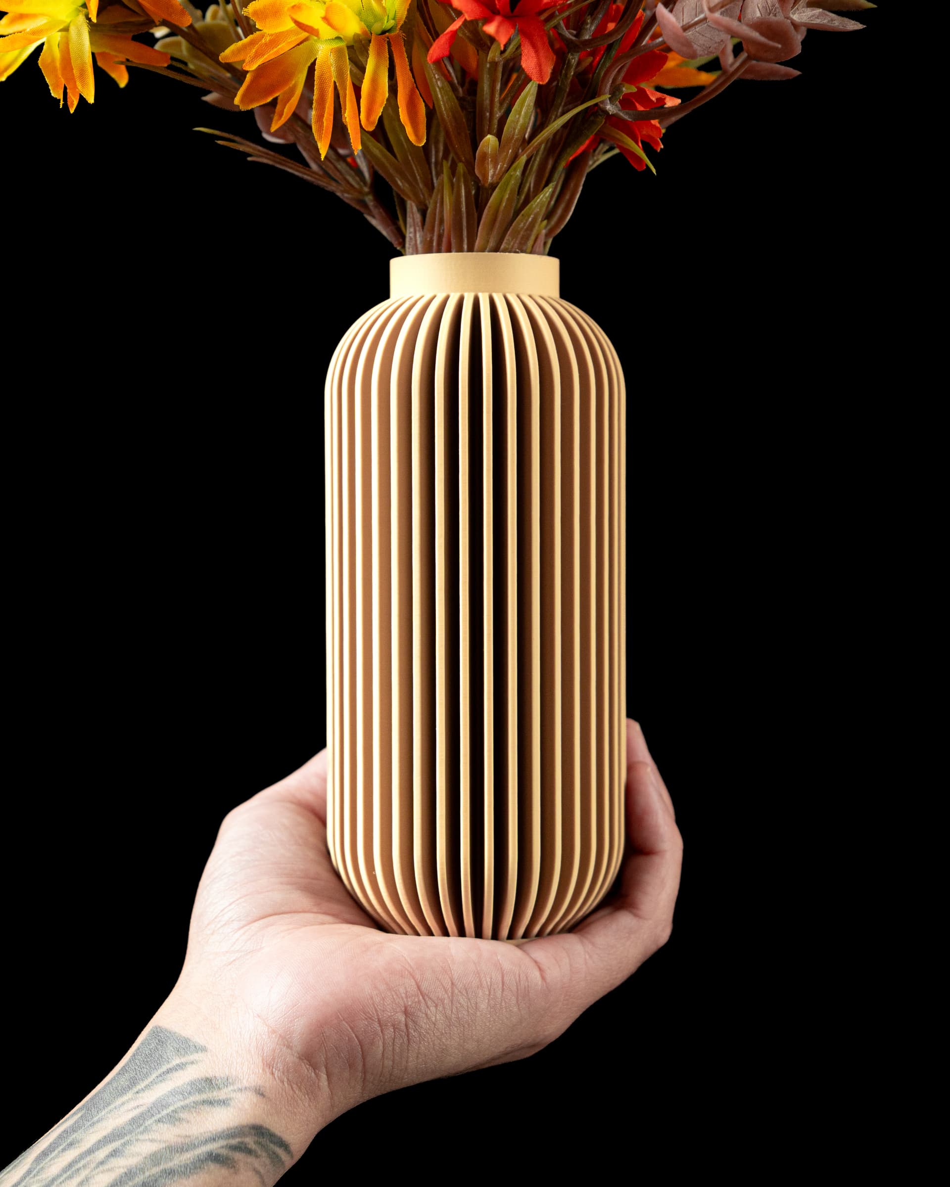 3D-gedruckte Yao Flower Vase — sandbeige Zylinder mit dichten vertikalen Lamellen, in Hand gehalten mit Herbstblumen
